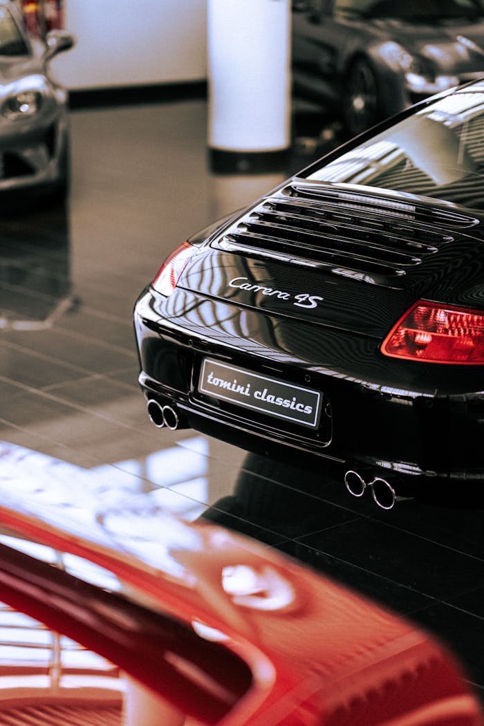 Elegant black Porsche Carrera 4S showcased in a modern showroom setting, highlighting luxury and automotive design.